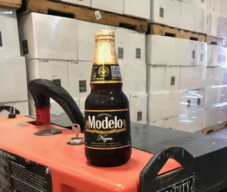 A bottle of Modelo placed in front of multiple wine boxes at Winter's Hill Estate.